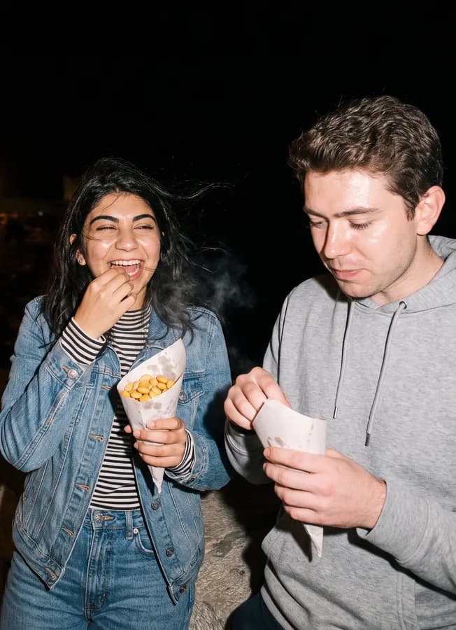 The two of them on the Alexandria sea wall at night, eating lupini beans out of paper cones