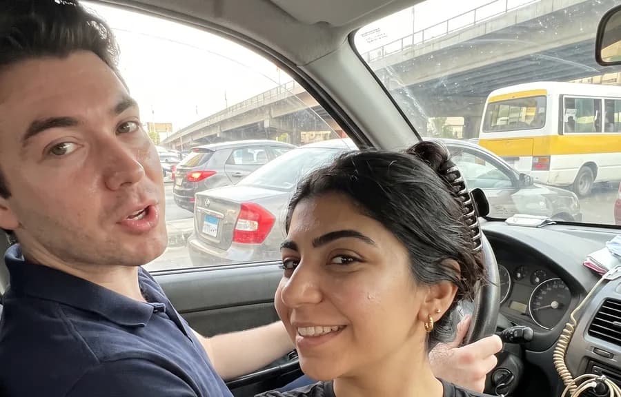 The two of them in the car, stuck in Cairo traffic under a flyover